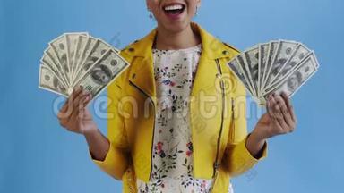 满意、快乐、兴奋的非洲裔美国妇女在蓝色背景上展示金钱和说上帝的上帝